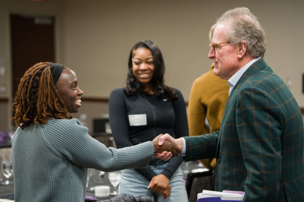 A handshake between two people at a luncheon.
