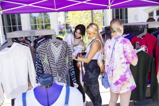 Tommie students browsing through clothes at pop-up event.