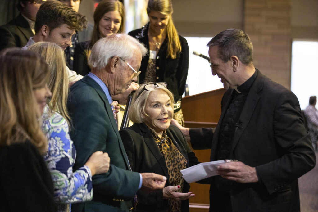 Father Chris Collins delivers a blessing to Susan Morrison and her family.