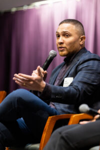 Jazz Hampton sitting on a panel and speaking