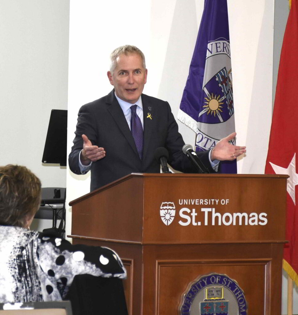 St. Thomas President Rob Vischer speaks at a podium.