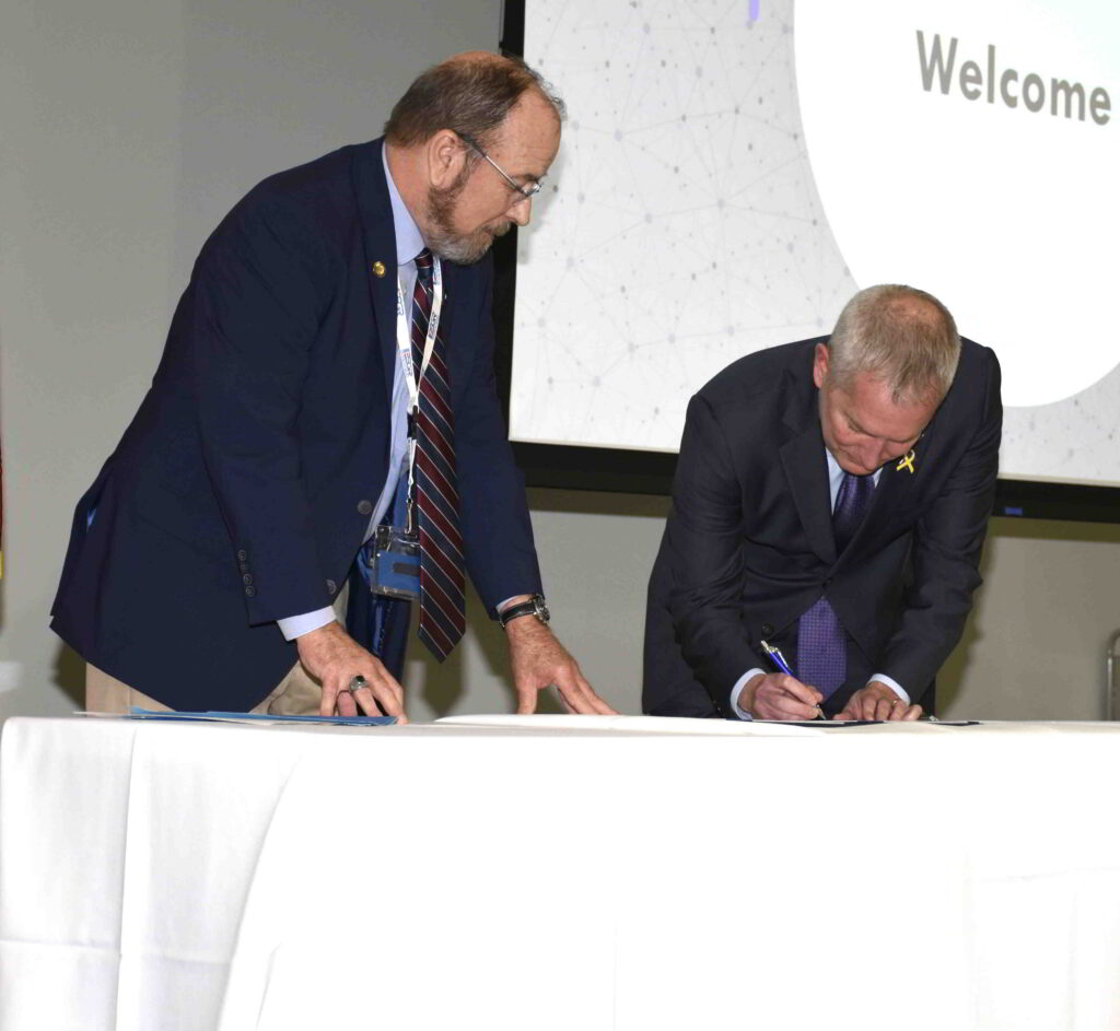 St. Thomas President Rob Vischer signs a document.