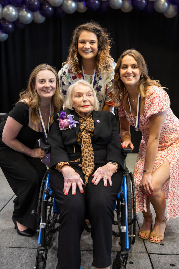 Three students pose with Susan S. Morrison for a photo.