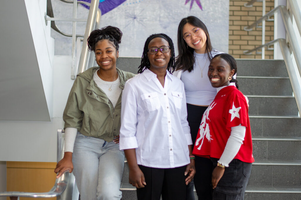 Dr. Vane Gichana on the stairs with her students.