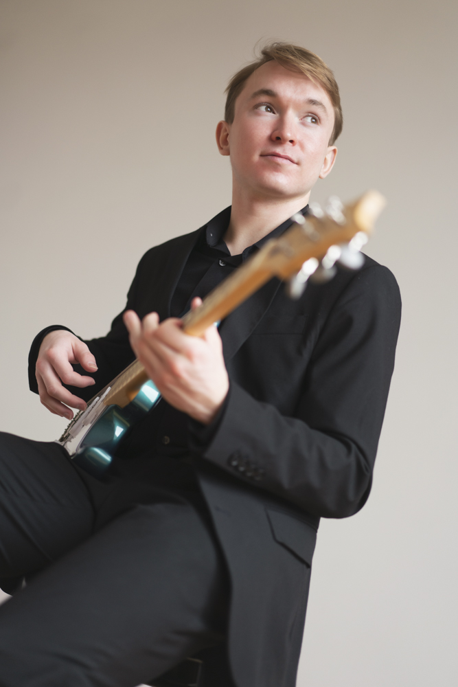 Benjamin Barrett poses with an electric guitar.