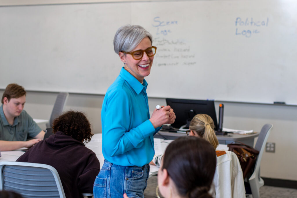 April Eichmeier smiles holding a dry erase marker.