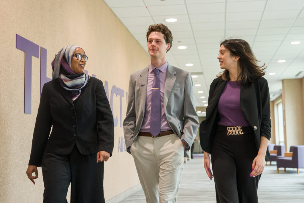 Three students walk down the hallway.
