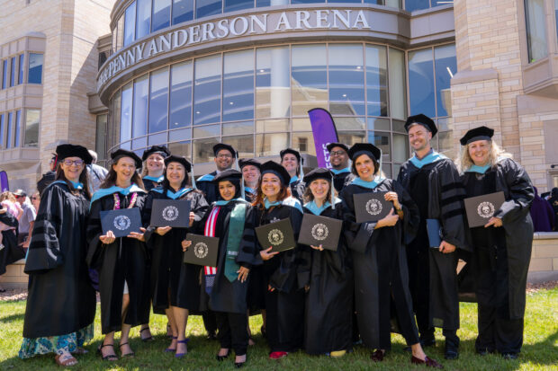Graduates pose with their diplomas during the Graduate Commencement Ceremony for the College of Arts & Sciences, The Saint Paul Seminary School of Divinity, School of Engineering and School of Education at Lee & Penny Anderson Arena in St. Paul on May 23, 2026.