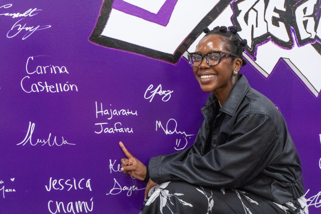 Hajaratu Jaafaru points at her name on the wall.