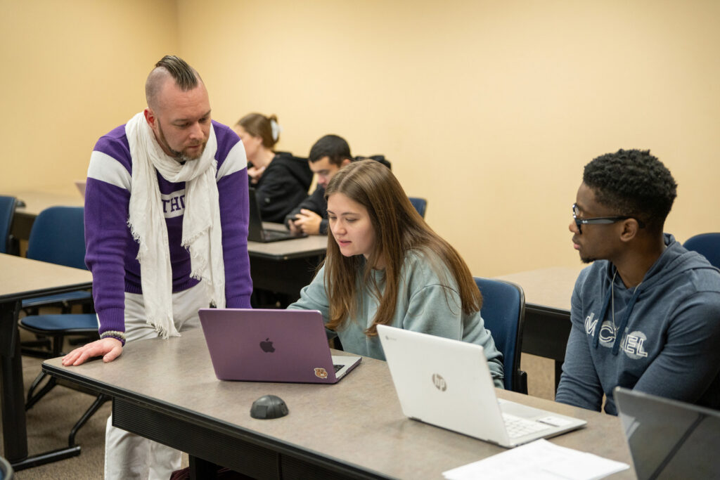 Seth Ketron interacting with two students.