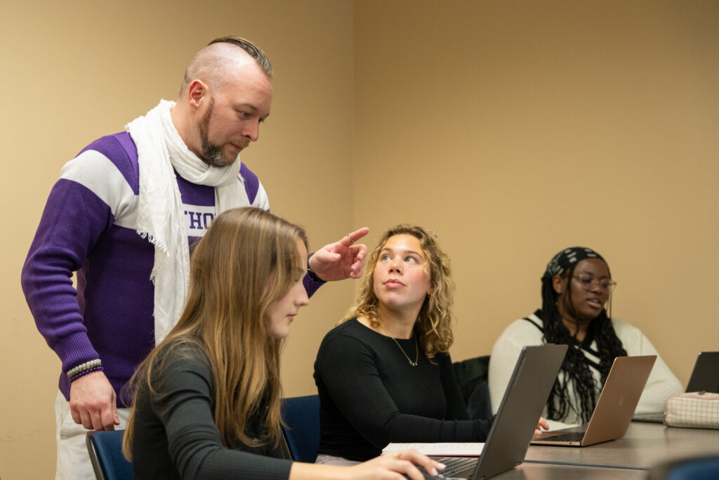 Seth Ketron talking to students with a laptop in front of them in a classroom.