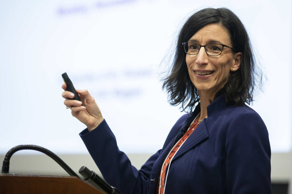 Susanne Wagner sitting in front of a projector for a presentation.