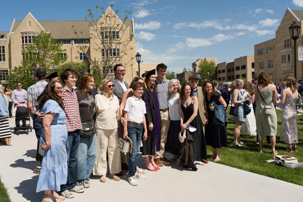a group gathers on the plaza for a photo at commencement