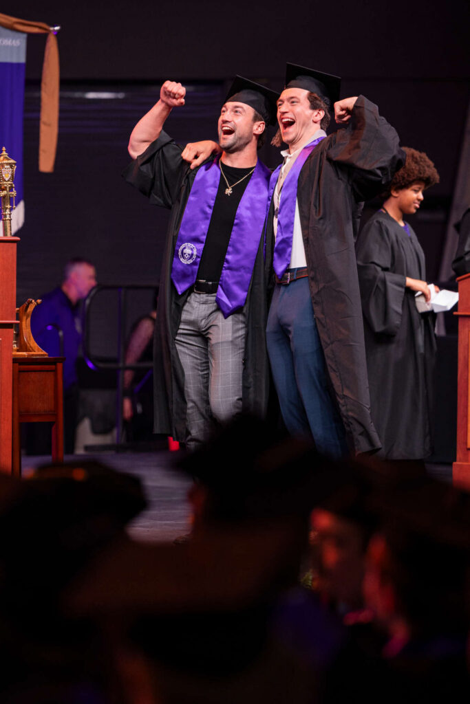 Students celebrate as they cross the stage at the Opus College of Business Undergraduate Ceremony in the Lee and Penny Anderson Arena on May 23, 2026 in St. Paul.