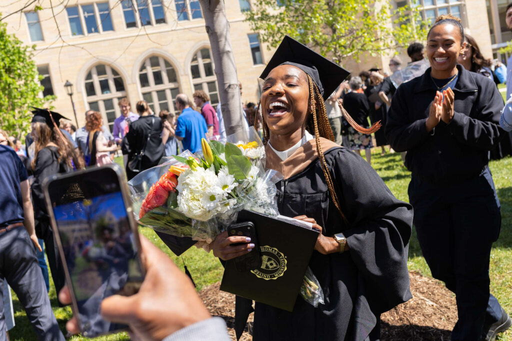A graduate celebrates after the Morrison Family College of Health and Opus College of Business Graduate Commencement Ceremony. Kurt Stepnitz/University of St. Thomas