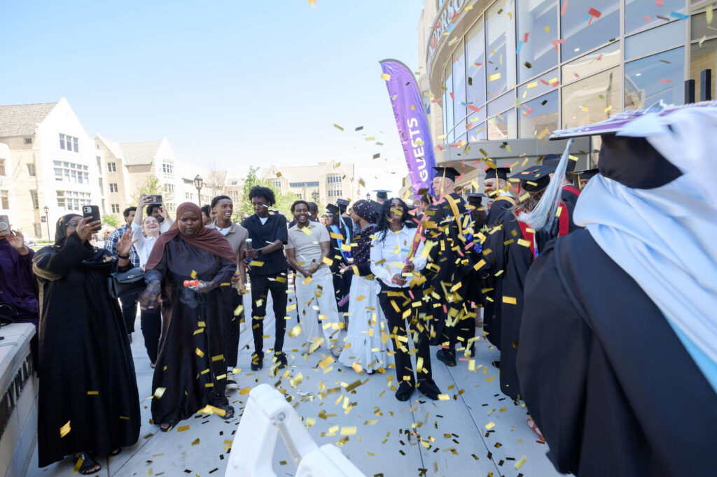 Confetti from the family surrounds a new graduate degree holder after the College of Arts & Sciences, School of Divinity, School of Engineering, School of Education Graduate Commencement Ceremony in the Lee & Penny Anderson Arena in St. Paul on May 24, 2026.