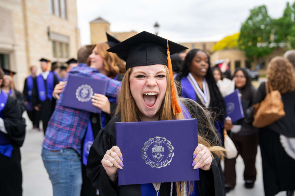 A graduate celebrates after the 2026 Morrison Family College of Health, School of Education and School of Engineering Undergraduate Commencement Ceremony. Mark Brown/University of St. Thomas