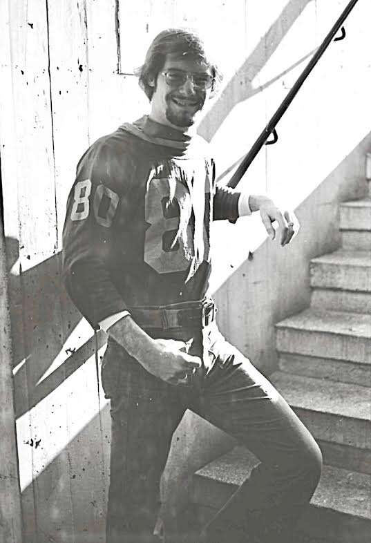 A black and white photo depicting a young Martin Strommer posing by a stairwell.