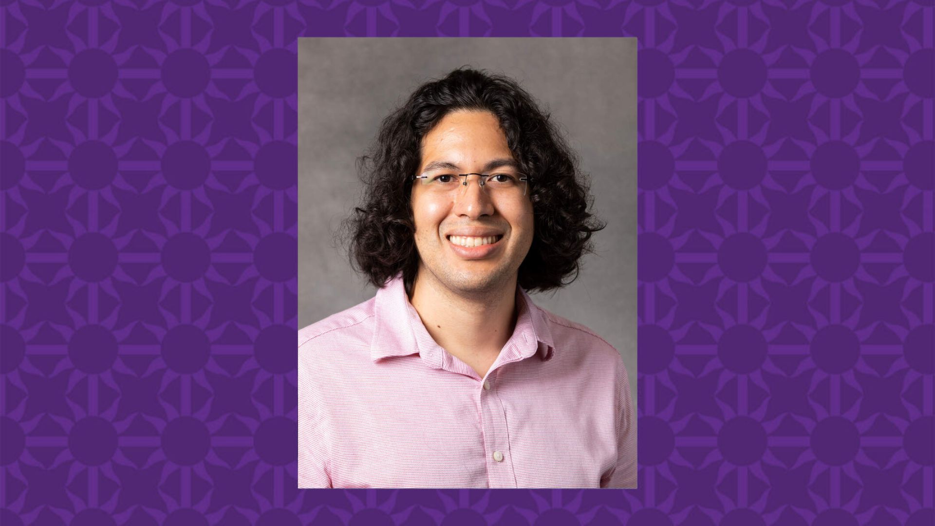 Alex Barrios smiles for a photo. There is a purple St. Thomas graphic that serves as a background.
