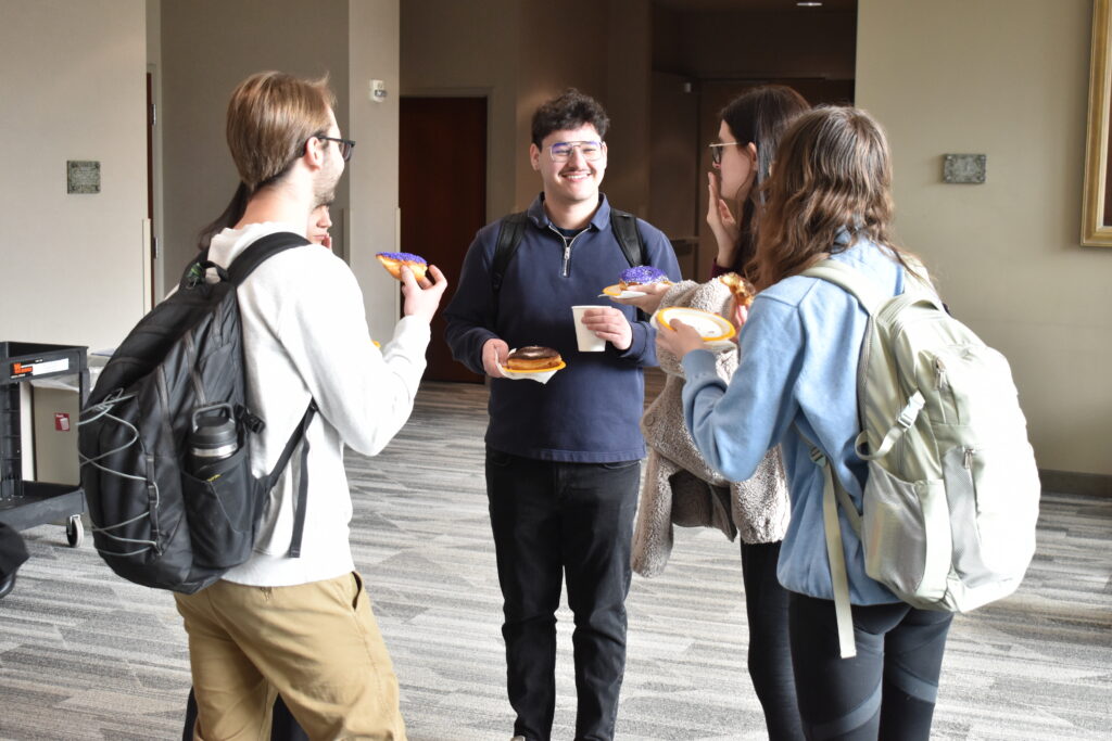 Five law students standing in a circle and talking with each other.
