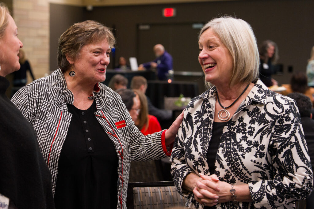 Karen Lange smiles while speaking with Dr. Amy F. Smith.