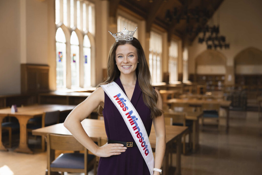 Anna Brennan posing for a portrait wearing a Miss Minnesota sash and crown.