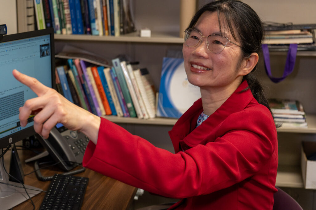 Candace Chou sits at her desk in front of her computer screen.