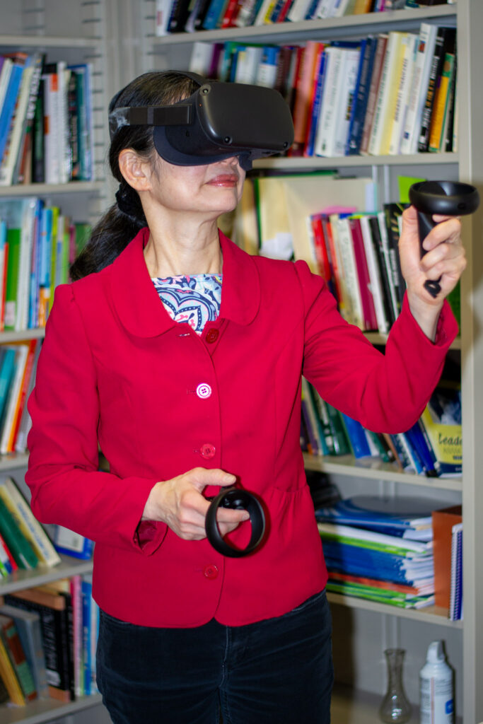 Candace Chou standing while using a pair of VR headsets.