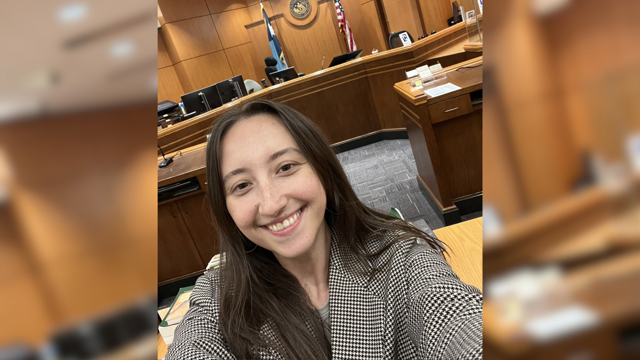 Kayla Abrams-Mahoney smiles for a selfie in an open court room.