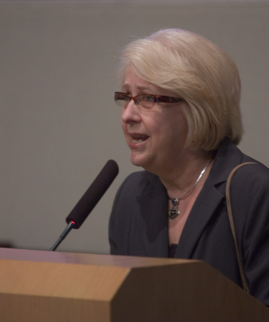 Miriam Williams speaking from a podium.