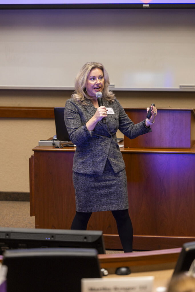 Danielle Campeau talking in an auditorium with a microphone.