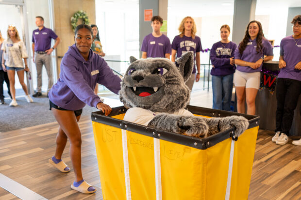 Rachel Theophilus '26 pushes mascot Tommie in a cart.