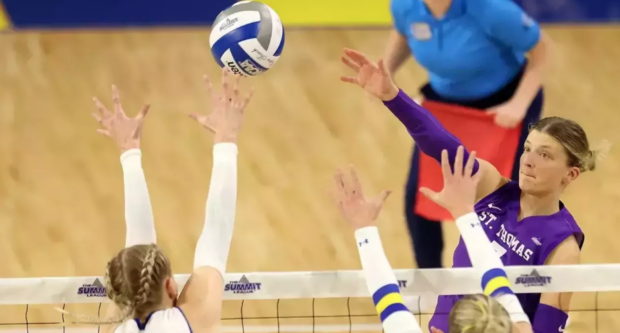 Tommie volleyball player spikes.