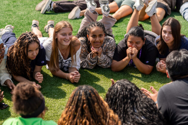 Students on the field huddled together for a campus bonding event.