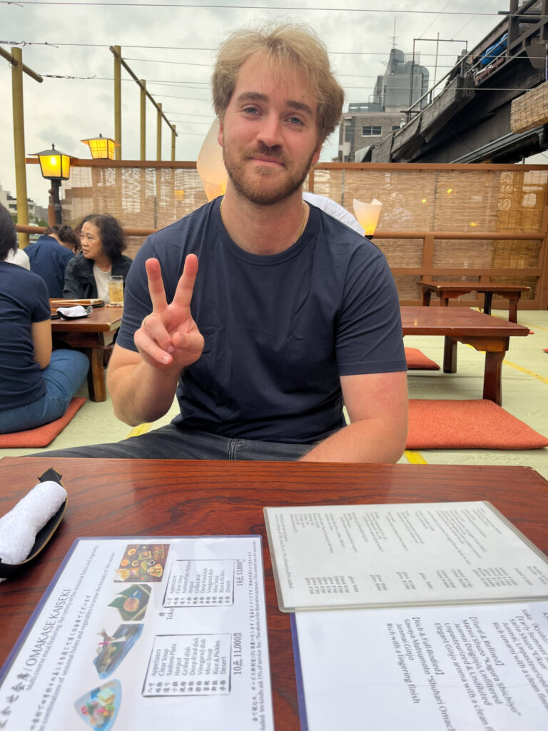 A student sits down at a restaurant patio during an international travel trip.