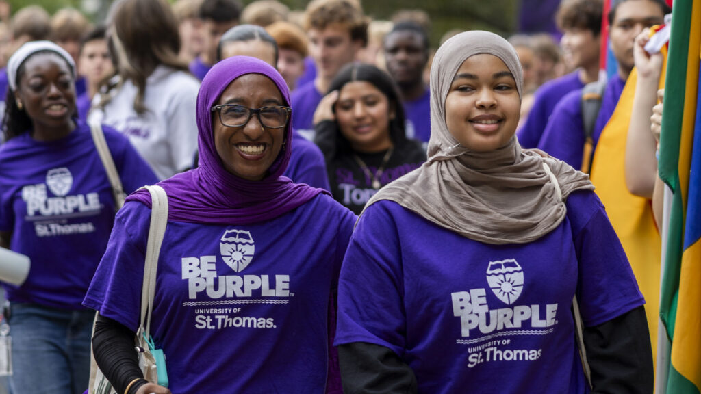 Two students smile while walking through the Arches.