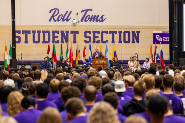 Students seated in an auditorium face the stage where President Rob Vischer speaks from the podium.