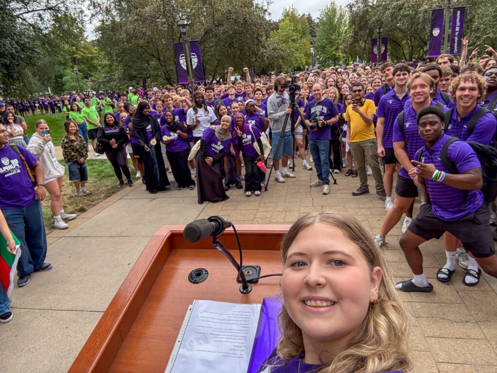 Renee Nies, behind the podium, takes a selfie with members of Class of 2030.