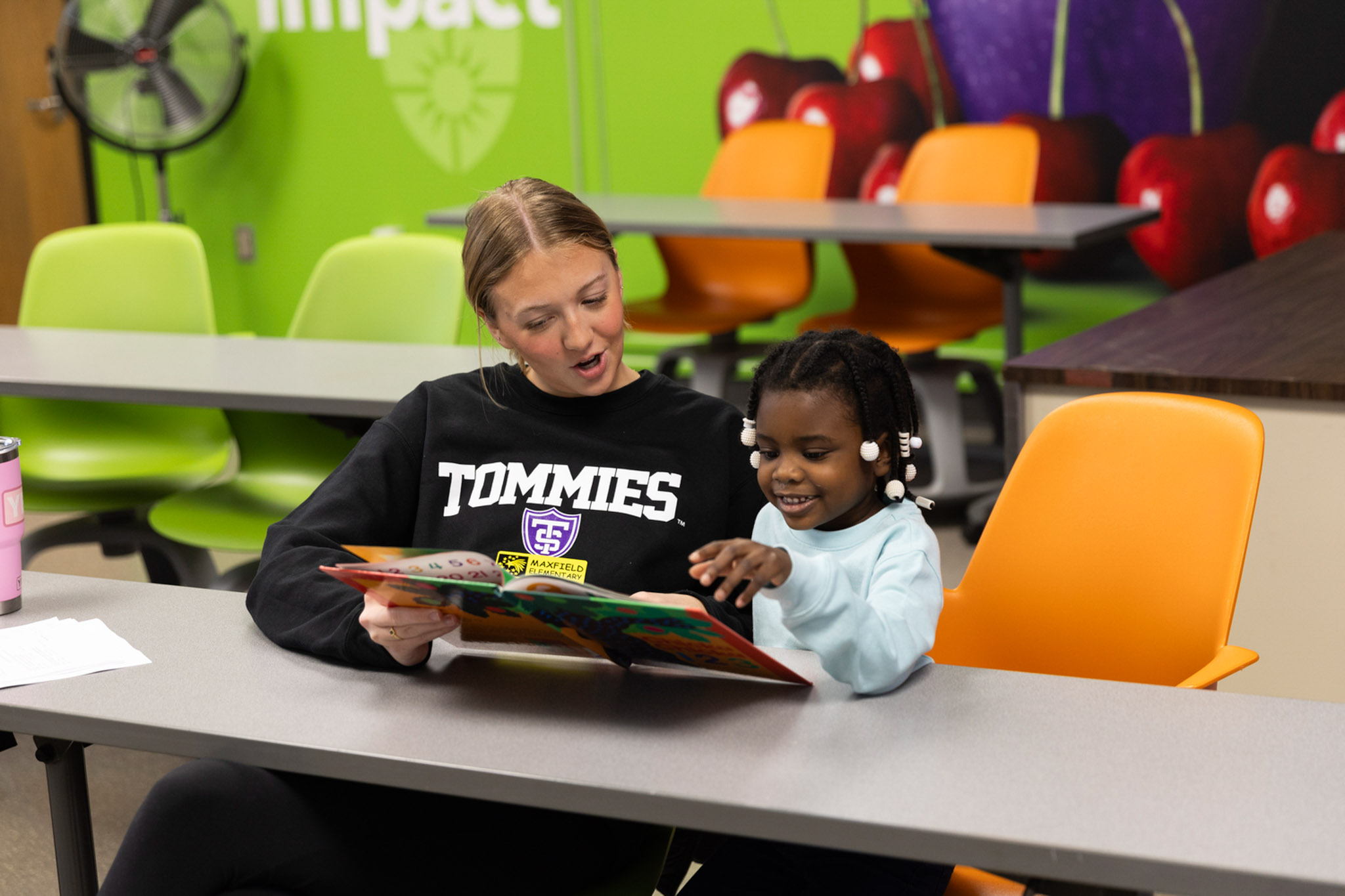 A St. Thomas student reads a book with a Maxfield Elementary student.