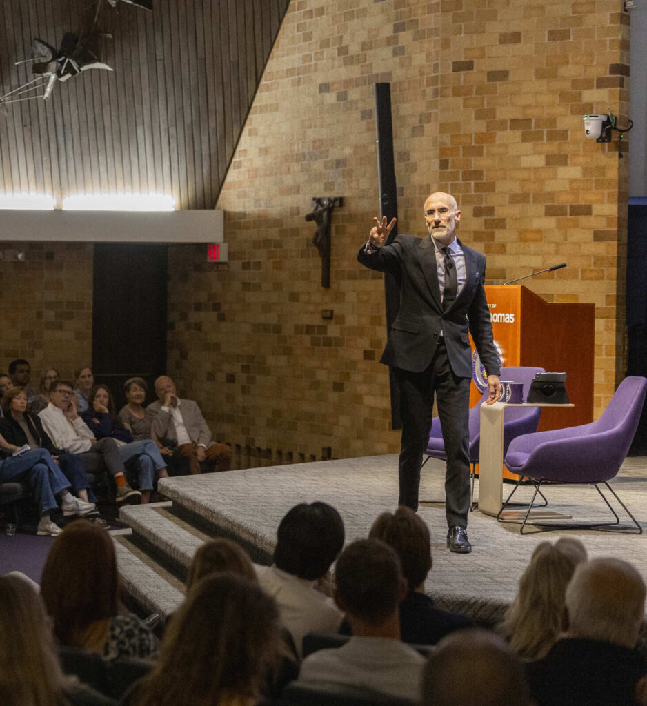 Arthur Brooks hold up "three" with his fingers, representing his three elements of meaning. 