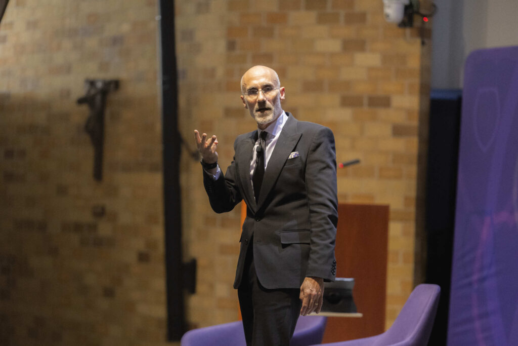 Arthur Brooks describes his "three elements of meaning" to the audience in the OEC auditorium. 