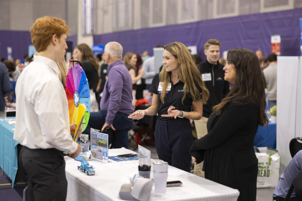An alumni recruiter speaks with a student at the career fair.