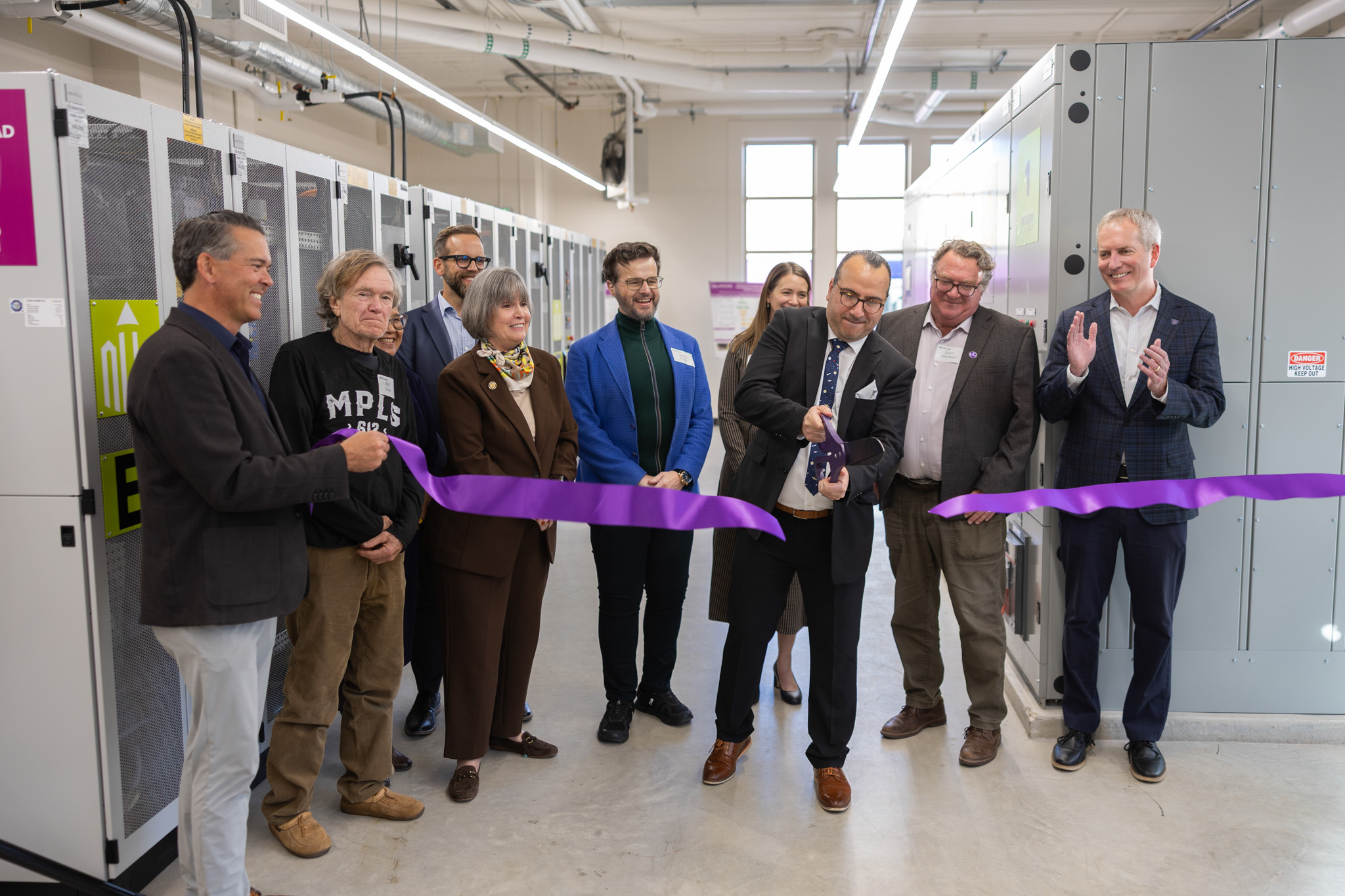 Mahmoud Kabalan cuts the ribbon with a giant pair of scissors.