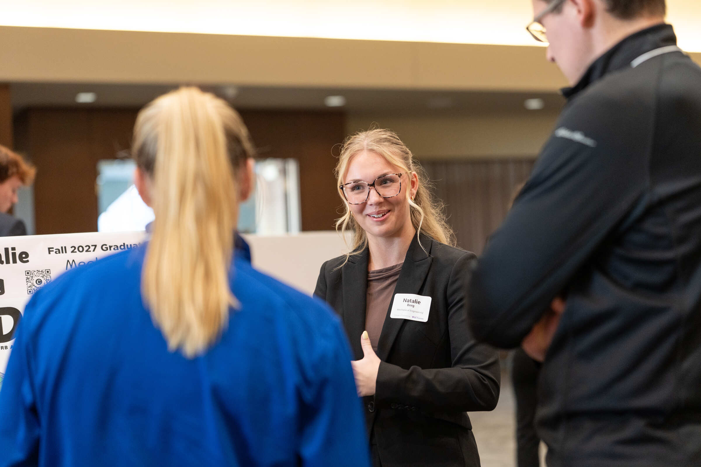 A student speaking with two recruiters.