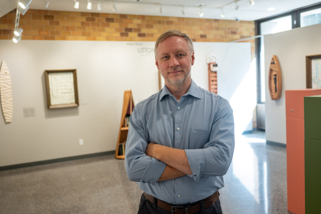 Mike Klein next to his "Littorally" exhibition.