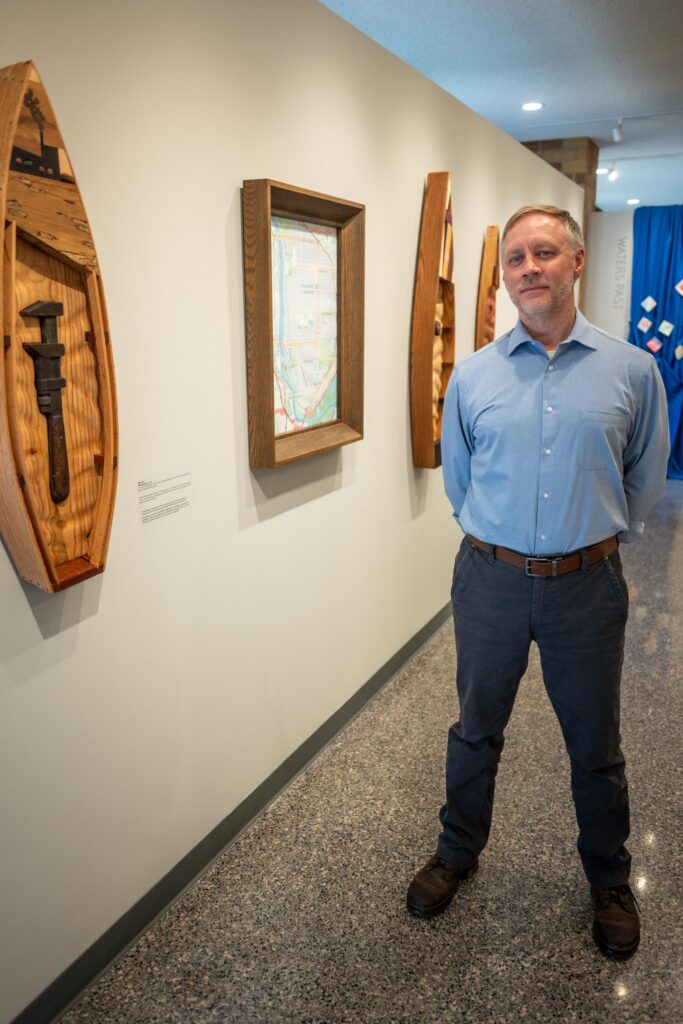 Mike Klein stands next to his hand-carved artwork titled "Monkeywrench."