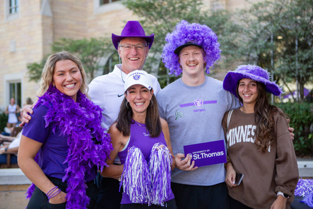 A family decked in all purple pose for a photo.