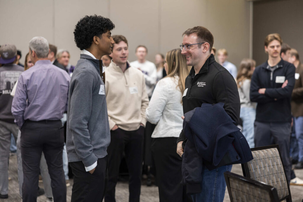 Two people talking to each other during an alumni networking event.