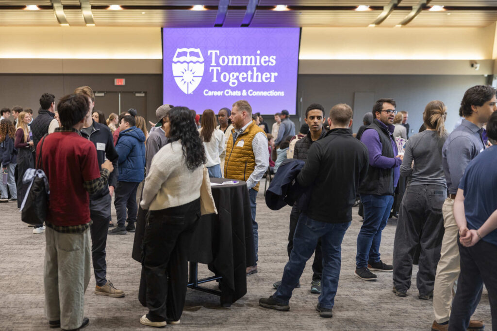 A wide shot of students and alumni gathering at Tommies Together.